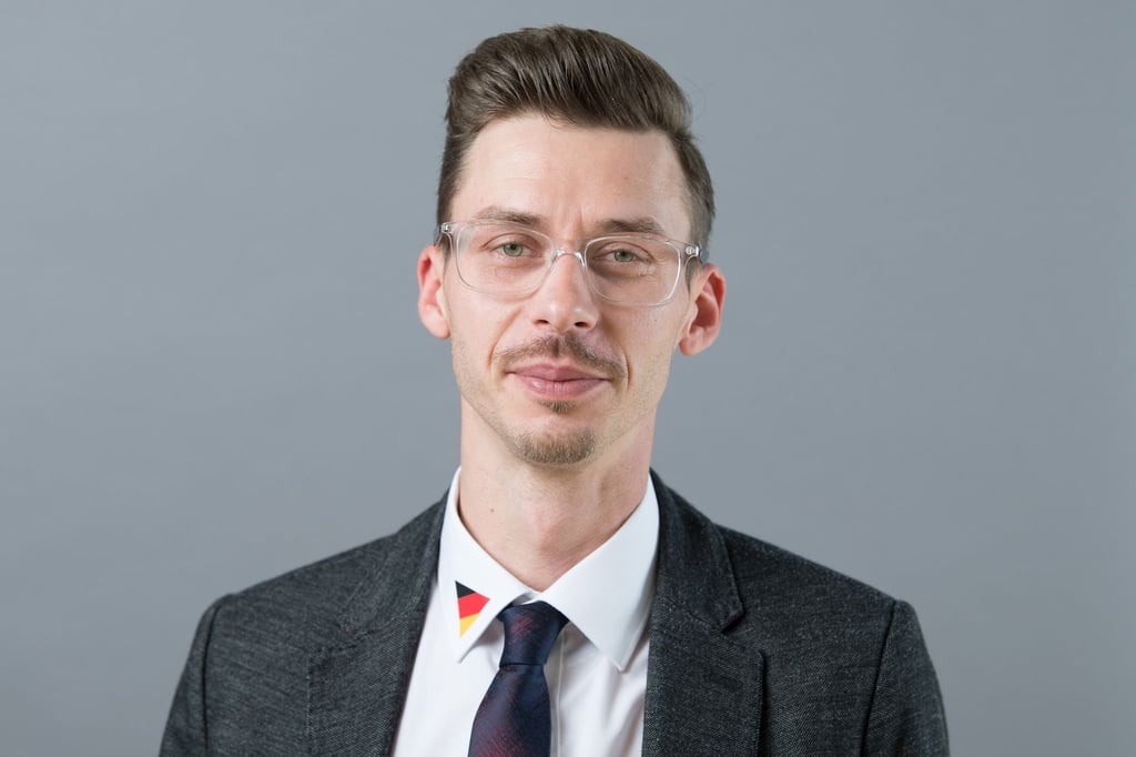 Mario Kumpf (AfD) steht anlässlich der konstituierenden Sitzung des sächsischen Landtags vor einer Fotowand.