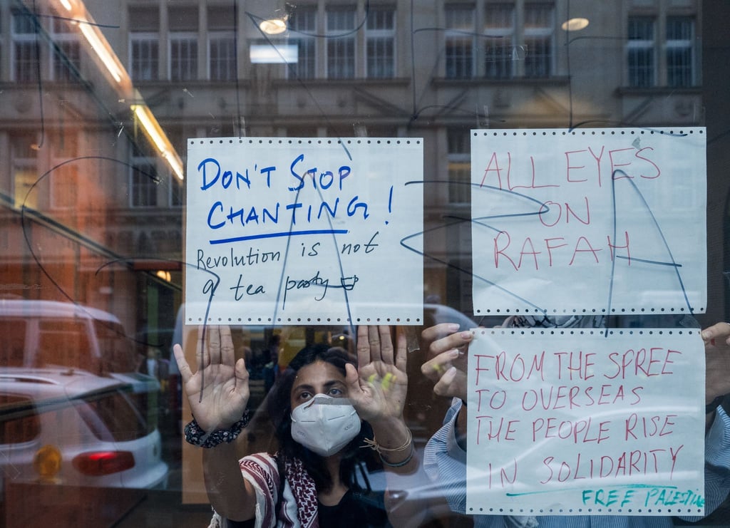 Pro-Palästinensische Demonstranten kleben im Institut für Sozialwissenschaften der Humboldt-Universität handgeschrieben Plakate von innen an die Scheibe.