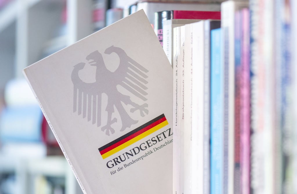 Ein Grundgesetz steckt in einem Bücherregal.
