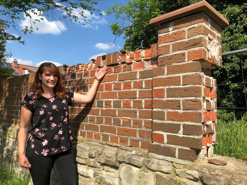Susan Schmidt zeigt einen Teil der kaputten Friedhofsmauer in Großkorbetha.