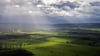 Sonnenstrahlen zwischen dunklen Wolken treffen auf Felder im Landkreis Hameln-Pyrmont.