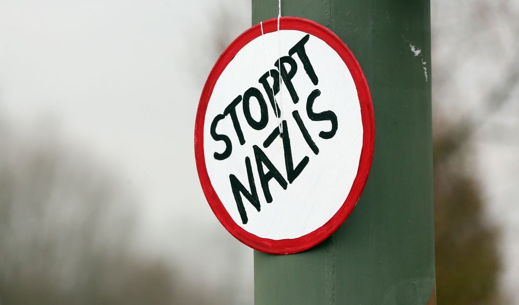 „Stoppt Nazis“ ist auf einem Schild am Rande einer Demonstration.
