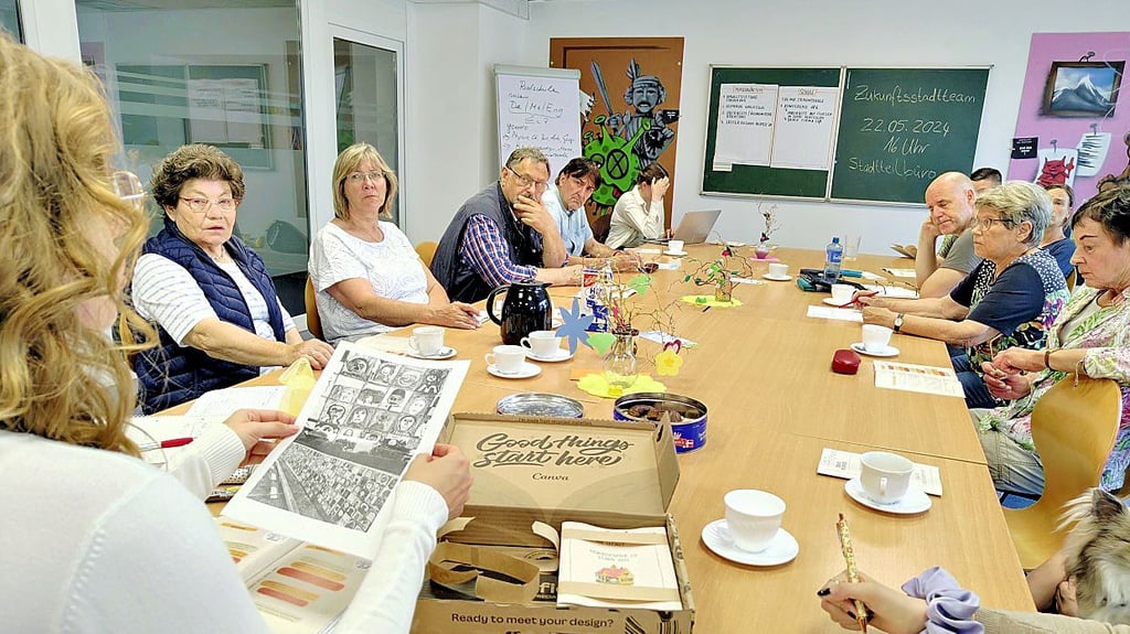 Janine Kaminski (vorne) vom Verein KinderStärken stellt dem Zukunftsstadtteam einen Entwurf für das Kunstwerk vor, die in Stendal entstehen soll.