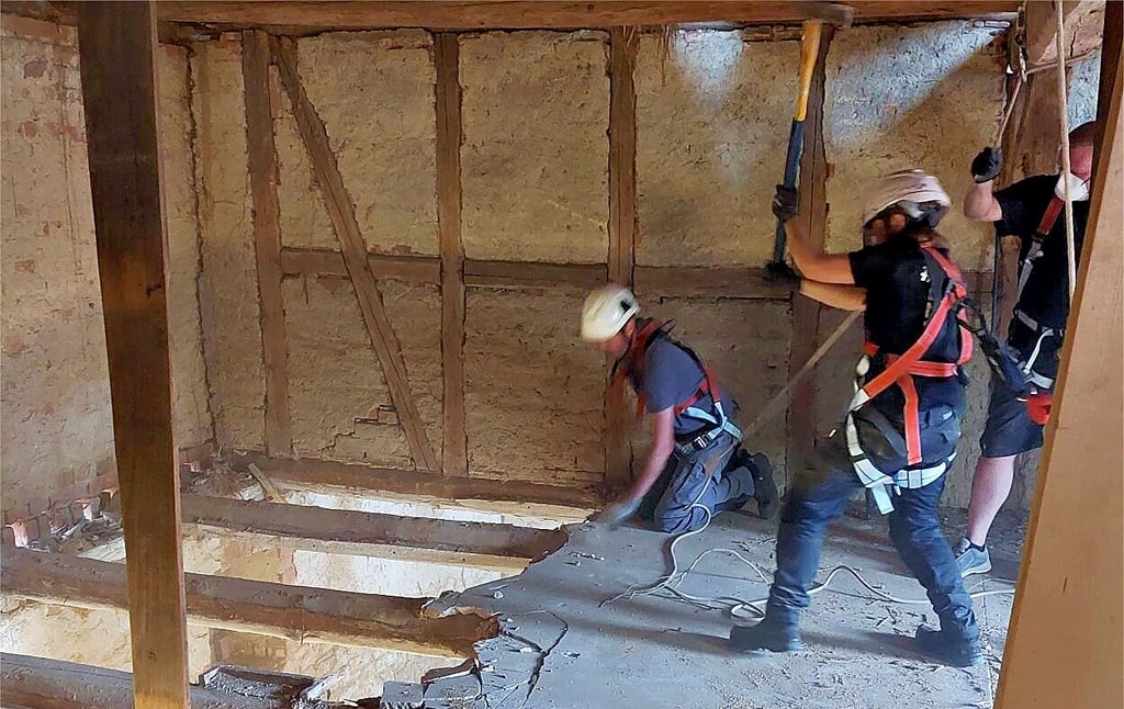 Abgesichert und mit vereinten Kräften wird beim Arbeitseinsatz der Rückbau der Zwischendecken in der künftigen Kulturscheune in Beendorf forciert.