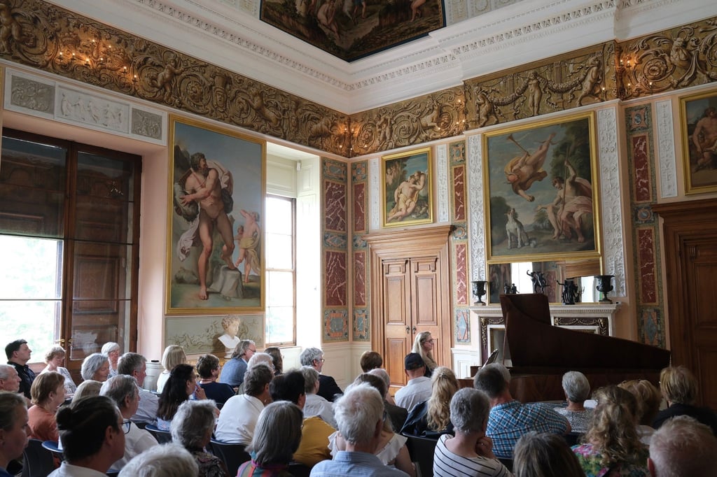 Besucher im Festassal des Wörlitzer Schlosses verfolgen ein Konzert von Ragna Schirmer auf einem historischen Hammerflügel.