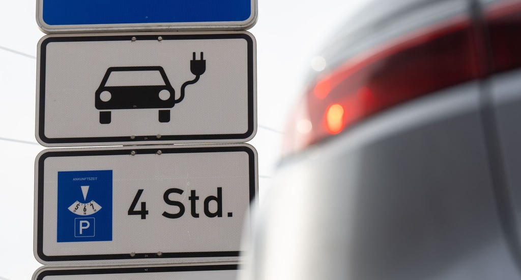 Ein Schild mit einem Signet für Elektroautos kennzeichnet einen Parkplatz für E-Fahrzeuge.