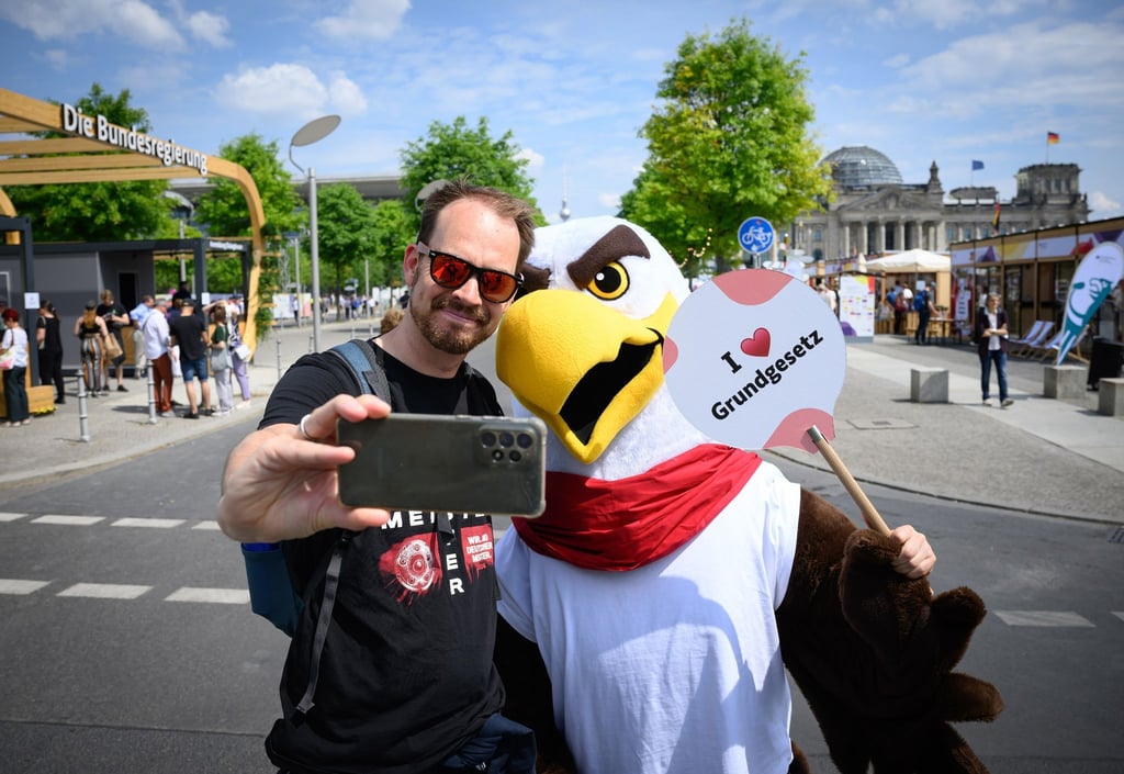 Besucher Bastian aus Bergisch-Gladbach macht mit „Freddi dem Familienadler“ ein Selfie: Andenken an die Feier für das Grundgesetz.