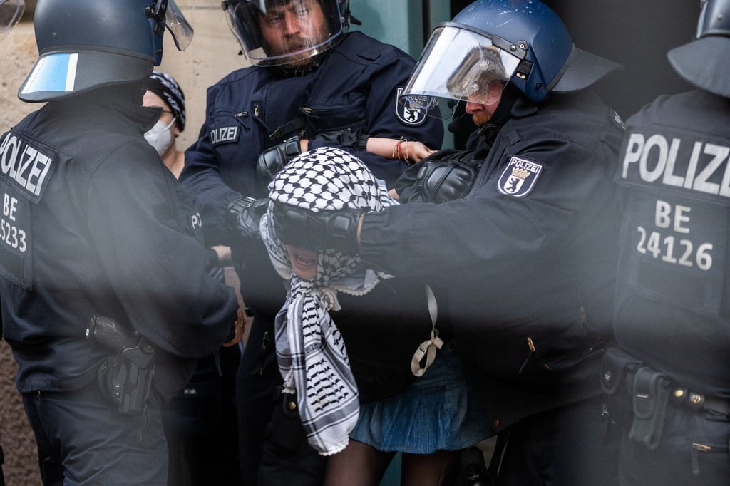 Eine der propalästinensischen Besetzerinnen der HU wird von Polizisten aus dem Gebäude gebracht.