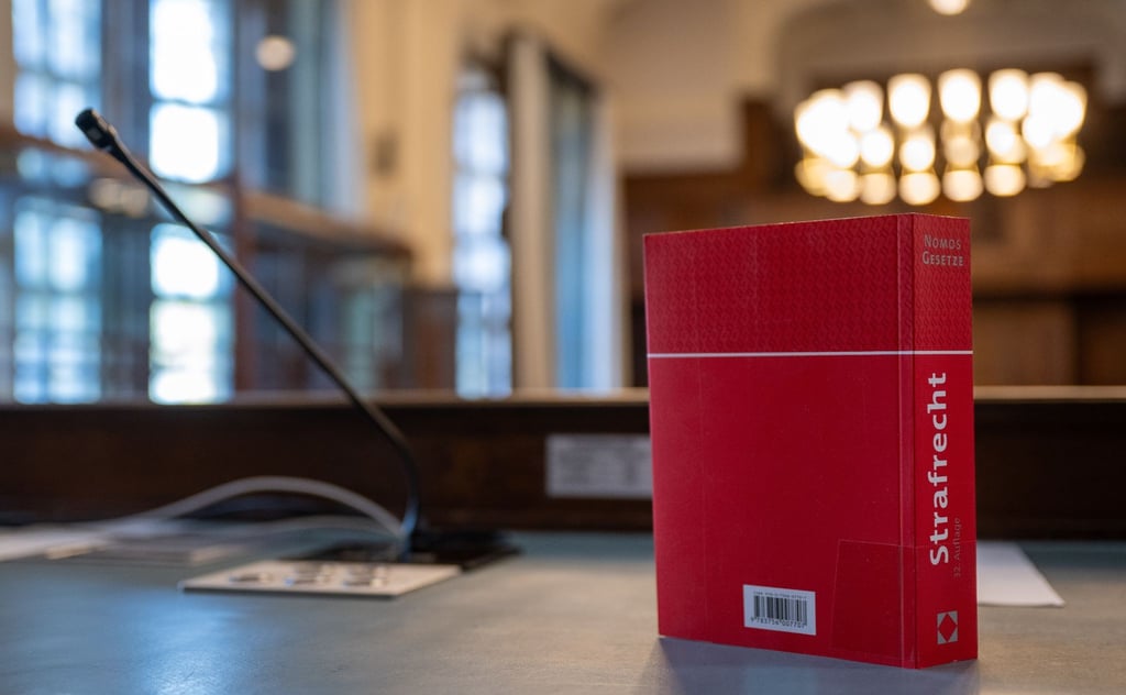 Das Strafgesetzbuch steht auf einem Tisch im Gericht.