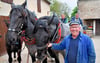 Burghard Bergmann gut gelaunt beim Anspannen der Pferde auf seinem Hof. Für das Fohlen "Leni" wird es die erste "Schulstunde".