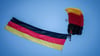 Fallschirmspringer der Bundespolizei mit Deutschlandfahne beim Staatsakt zu „75 Jahre Grundgesetz“.