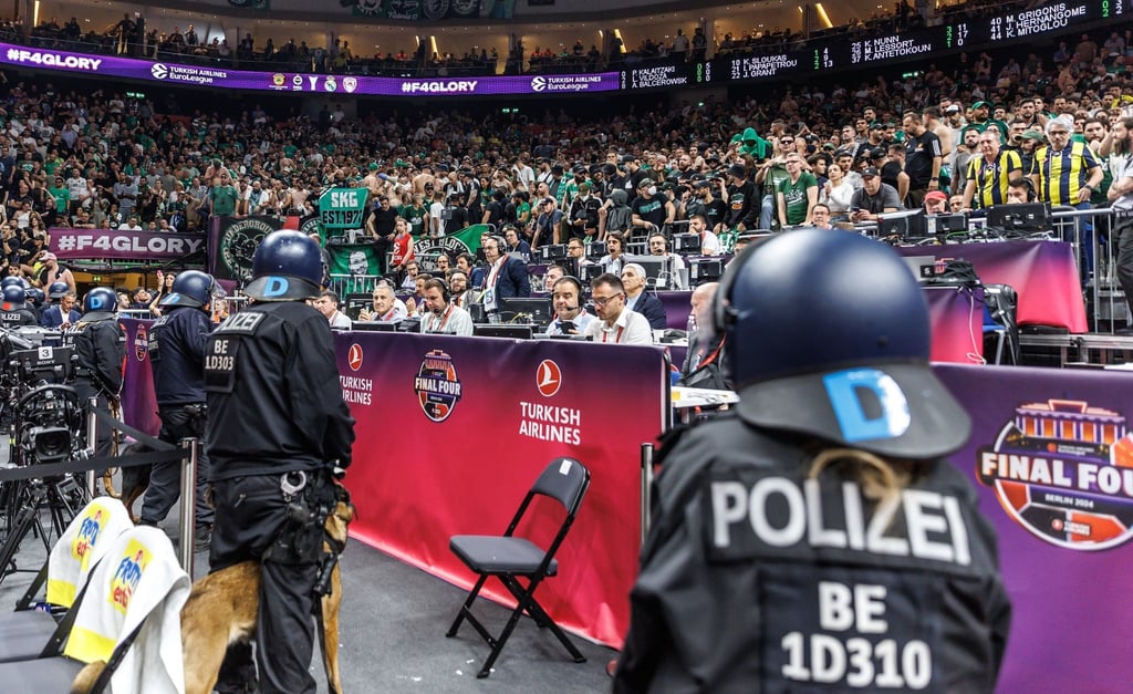 Polizisten stehen vor den Fans beider Teams.