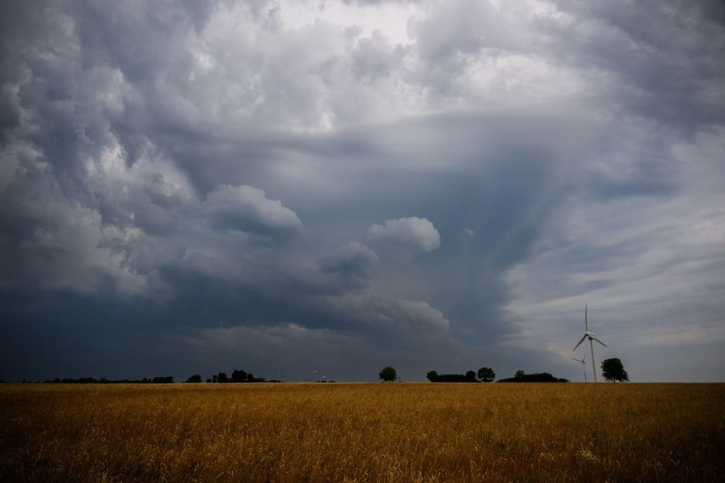 Dunkle Wolken ziehen über einem Windrad in der Region Hannover hinweg.