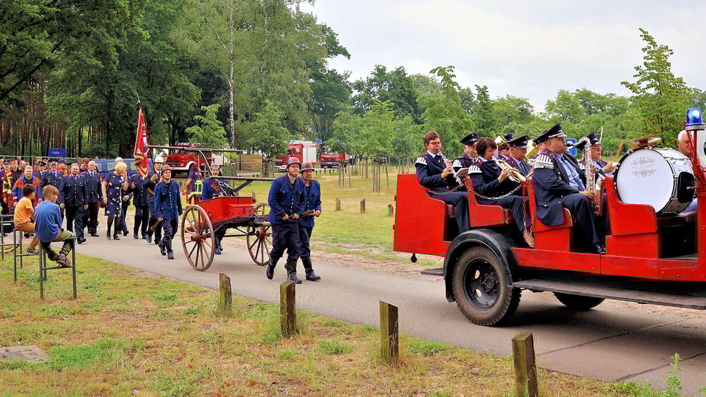 Die Feierlichkeiten zum 90-jährigen Gründungsjubiläum der Feuerwehr Kamern begannen mit dem Umzug vom Gerätehaus durch das Dorf zum Festplatz am See. Vornweg im Oldtimer begleitete die Feuerwehrkapelle Elbe-Havel-Land den Zug. Gleich dahinter wird die alte Handdruckspritze von Feuerwehrleuten in historischen Uniformen gezogen.