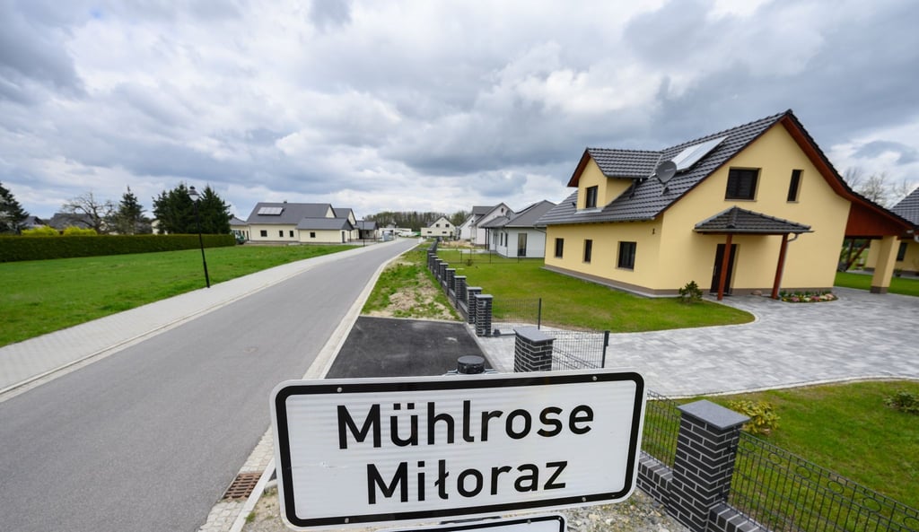Eine Ortstafel steht im sogenannten Neu-Mühlrose, dem neuen Ansiedlungsstandort von Mühlrose, vor neu gebauten Häusern an der Straße.