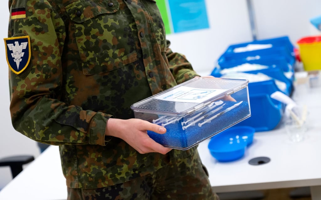 Eine Soldatin der Bundeswehr trägt im Impfzentrum eine Kiste mit Spritzen gegen das Coronavirus (Biontech).