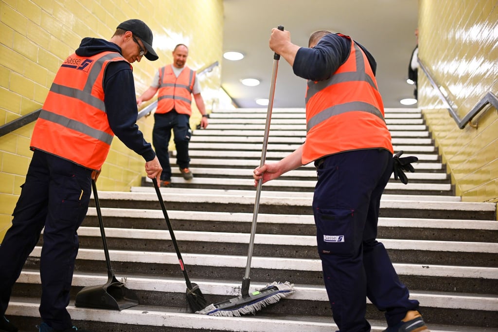 Reinigungskräfte arbeiten auf einer Treppe in der U-Bahnline U8.