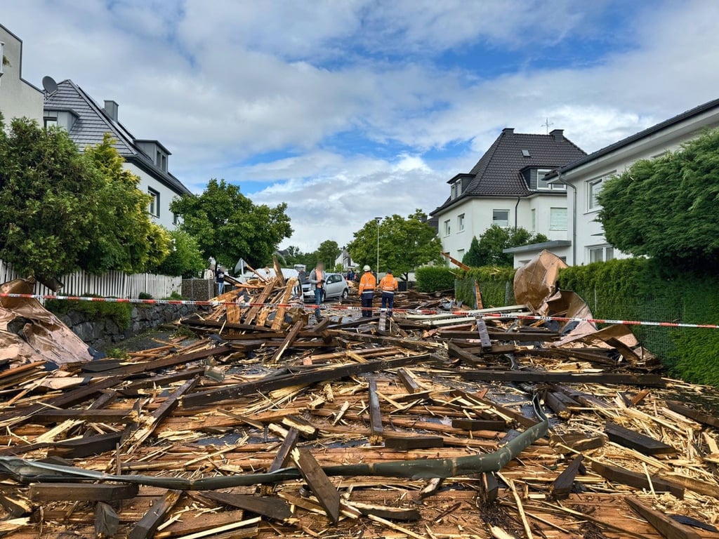Trümmer des Kirchturmdaches liegen auf der Straße: Der Dachstuhl wurde nun völlig zerstört.