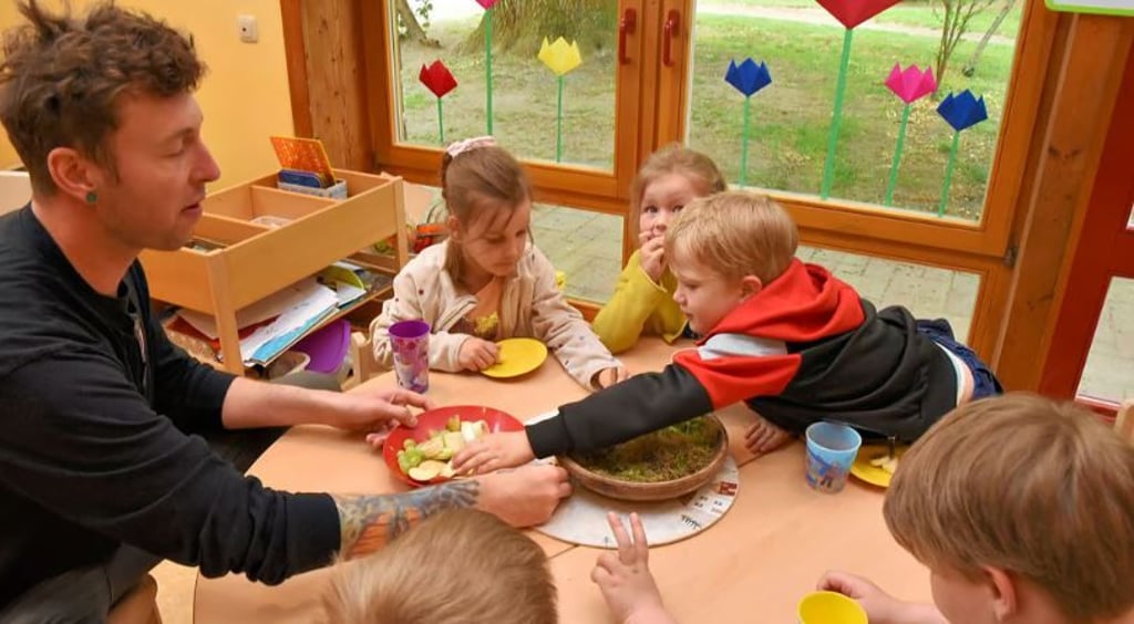 Knirpse der christlichen Kindertagesstätte Gnadau beim Obstfrühstück. Der 31-jährige Thomas Gaul absolviert ein 600-Stunden-Praktikum, weil er Erzieher werden möchte.
