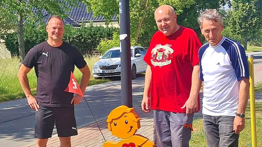 Ortsbürgermeister Steve Daniel (l.) mit Stefan Nolte und Frank Elze neben einer der Figuren im Siedlungsweg.