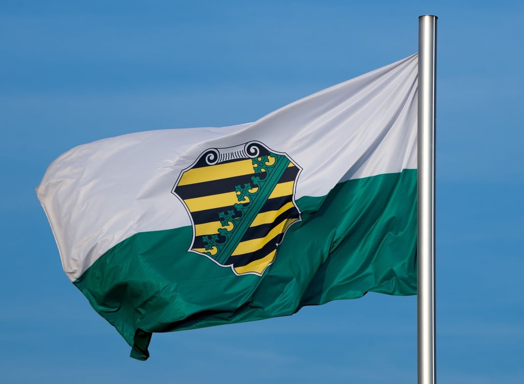 Die Flagge vom Bundesland Sachsen mit dem sächsischen Wappen weht im Wind.