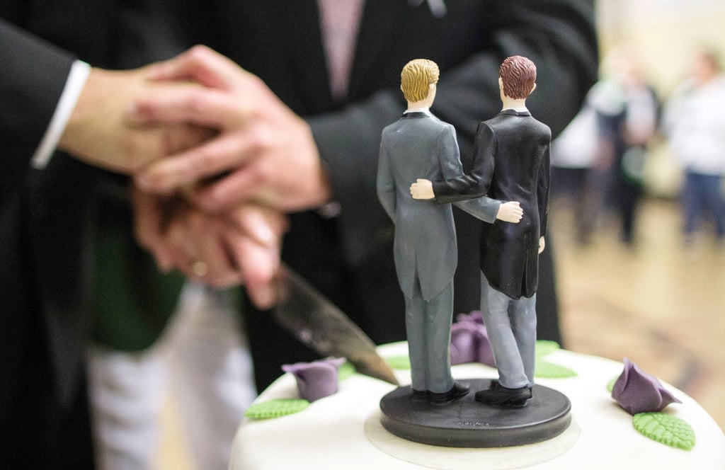 Zwei Männer schneiden nach ihrer Eheschliessung im Rathaus von Hamm eine Hochzeitstorte an.