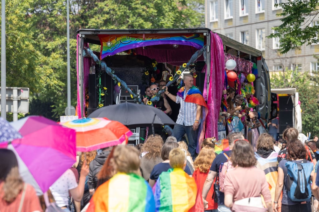 Menschen feiern bei der Parade zum Christopher Street Day in der Sächsischen Landeshauptstadt auf einem Wagen bei der Fahrt durch die Straßen.