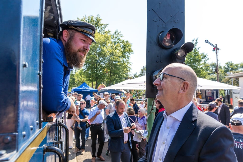 Dietmar Woidke (SPD), Ministerpräsident des Landes Brandenburg, begrüßt den Lokführer einer Dampflok beim 70. Geburtstag der Cottbuser Parkeisenbahn.