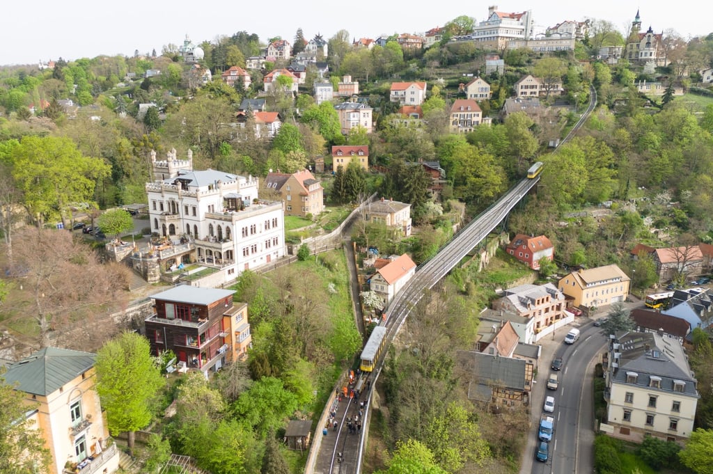 Ein Wagen der Standseilbahn zieht im Rahmen der Hauptuntersuchung neue Bahnschwellen mit einem angehängten Wagen auf der Strecke zwischen dem Dresdner Stadtteil Loschwitz und Weißer Hirsch (Aufnahme mit einer Drohne).