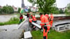 Mitarbeiter des Neu-Ulmer Baubetriebshofs bringen Schutzwände an der Donau an.