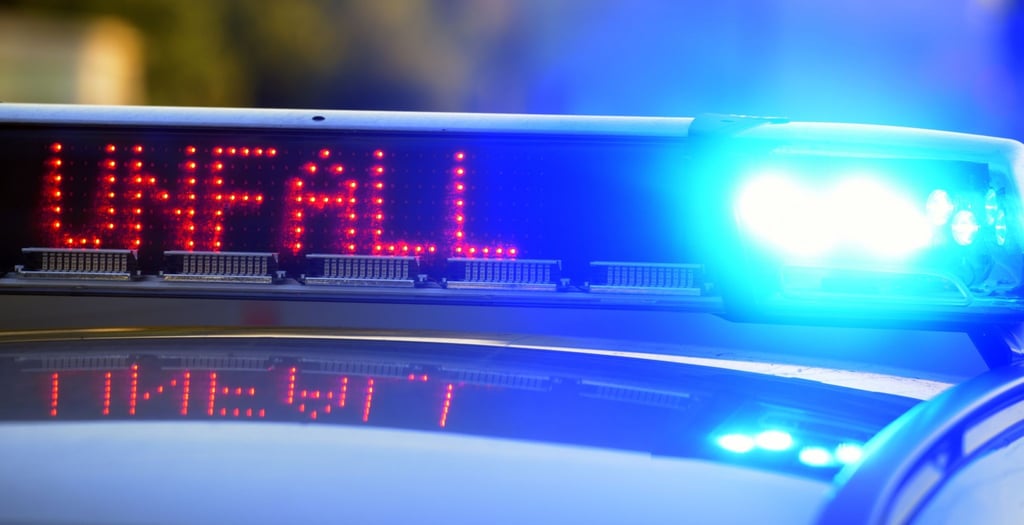 Auf einem Polizeifahrzeug warnt eine Leuchtschrift vor einer Unfallstelle.