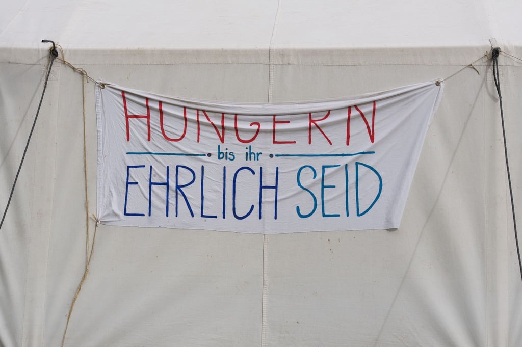 Ein Transparent mit der Aufschrift „Hungern bis ihr ehrlich seid“ hängt im Hungerstreik-Camp.