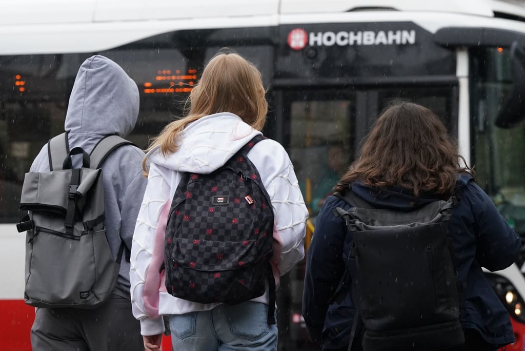 Schülerinnen und Schüler steigen in einen Bus.