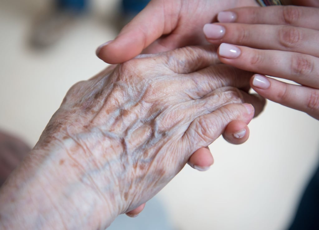 Eine Pflegerin hält die Hand einer Bewohnerin im Seniorenzentrum Sankt Elisabeth.