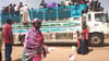 Menschen besteigen einen Lastwagen, um eine Stadt im Sudan zu verlassen.