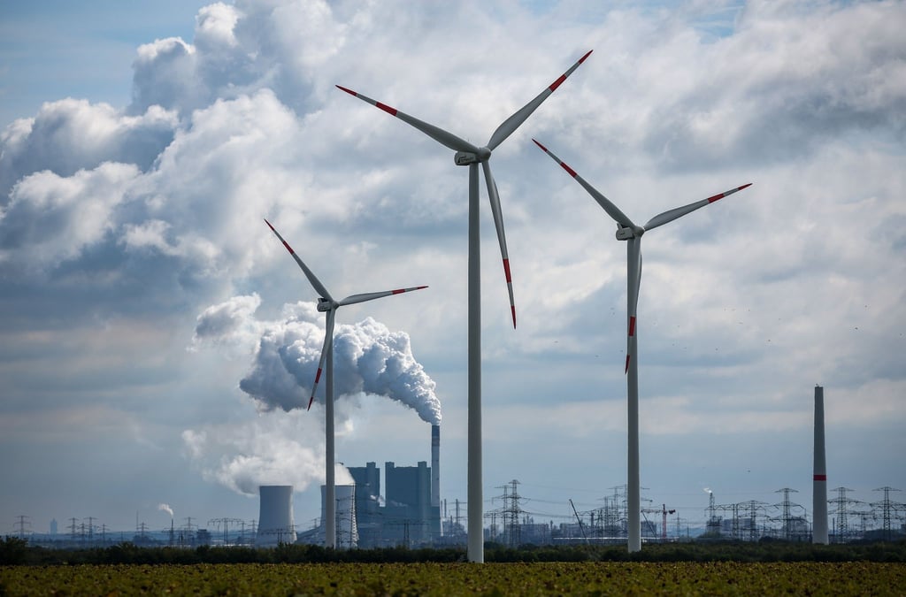 Windräder drehen sich vor der Kulisse des Braunkohlekraftwerks Schkopau westlich von Halle (Saale).