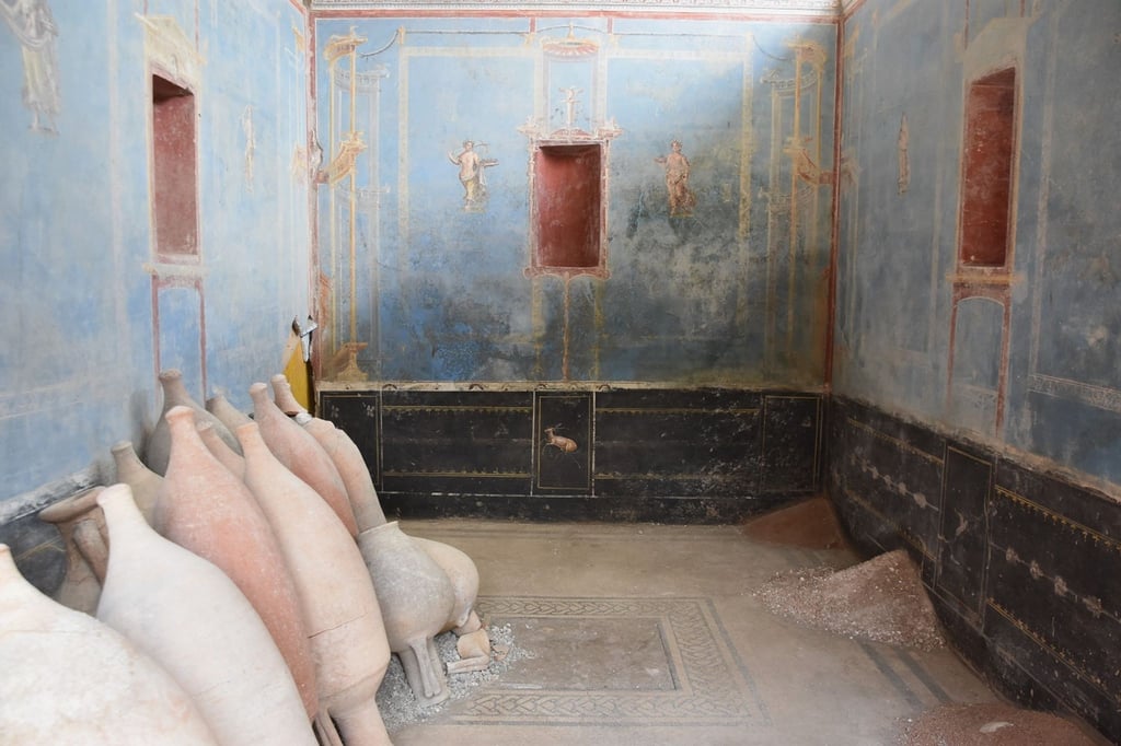 Ein Raum mit blauen Wänden und gemalten weiblichen Figuren ist in Pompeji freigelegt worden.