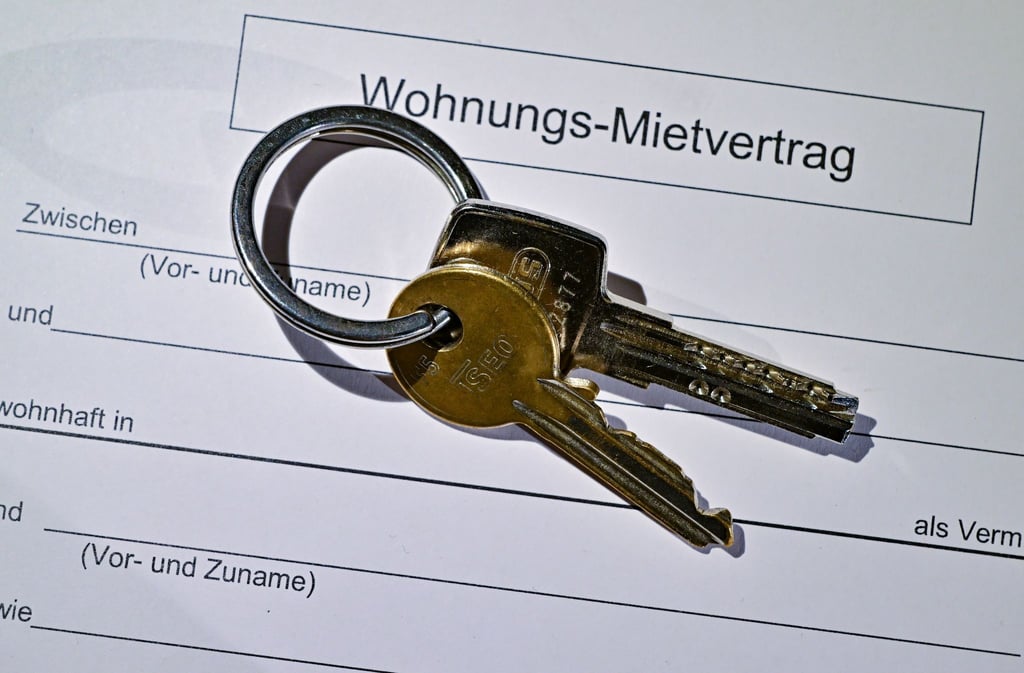 Ein Wohnungsschlüssel liegt auf einem Mietvertrag für eine Wohnung.