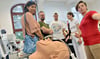 Sylvana Schurz (re.), Master-Studentin im zweiten Semester, erklärt Besuchern beim Hochschulinformationstag  ein  Beatmungsgerät.