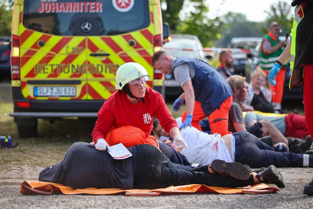 Notfallsanitäter in Ausbildung versorgen während einer Übung Menschen.