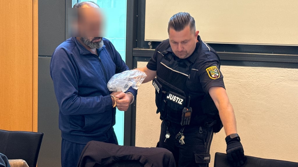 Der Angeklagte wird in Handschellen in den Saal geführt.