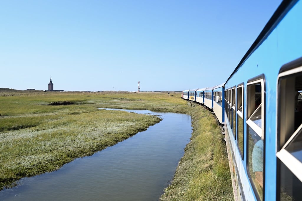 Die Inselbahn fährt über die Salzwiesen und bringt Urlauber von der Fähre zum Bahnhof.