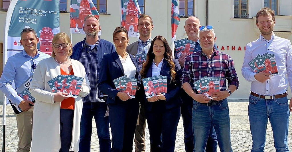 Vertreter der Stadt Stendal, des Landes Sachsen-Anhalt, Sponsoren und Radiohäuser präsentieren gemeinsam das Programmheft zum Sachsen-Anhalt-Tag 2024.