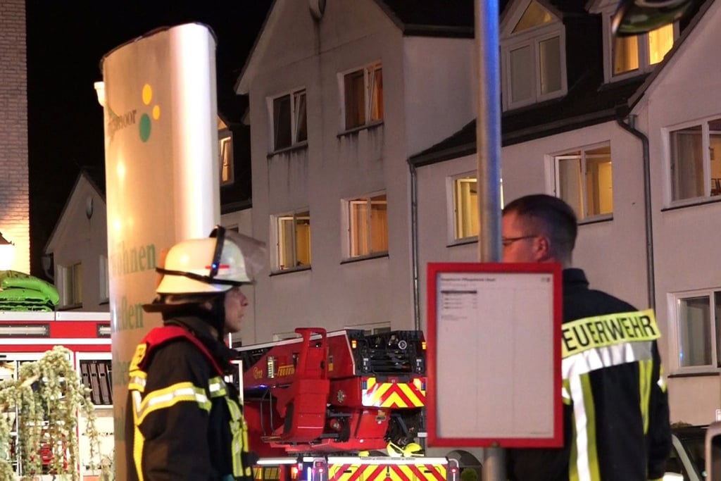 Feuerwehrleute arbeiten vor einem Seniorenheim.