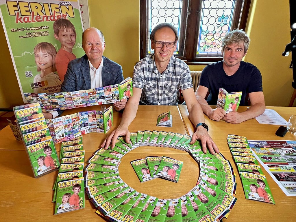 Paul Koller (von links), Thomas Haedicke und Lars Höfinghoff präsentieren den Ferienkalender der Stadt Bernburg für das Jahr 2024.