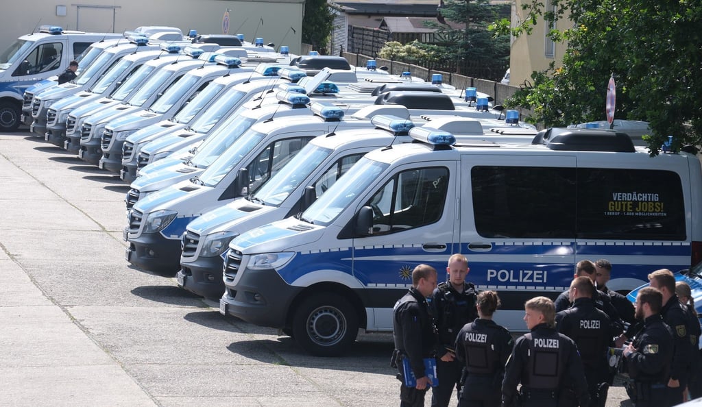 Polizisten versammeln sich auf einem Parkplatz.