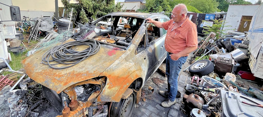 Claus Helmecke vor einem der beiden ausgebrannten Autos. Er zeigt die Stelle, wo auf den Zafira eingeschlagen wurde, um die Frontscheibe zu zertrümmern und einen Brandsatz ins Auto zu werfen. Der Rentner aus Tangerhütte wollte die Autos eigentlich weiterverkaufen.