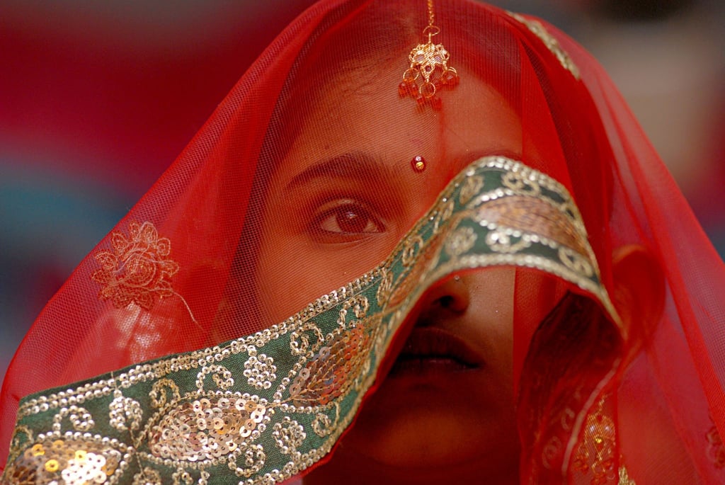Eine junge Braut während einer Massenheirats- und Verlobungszeremonie in Indien.