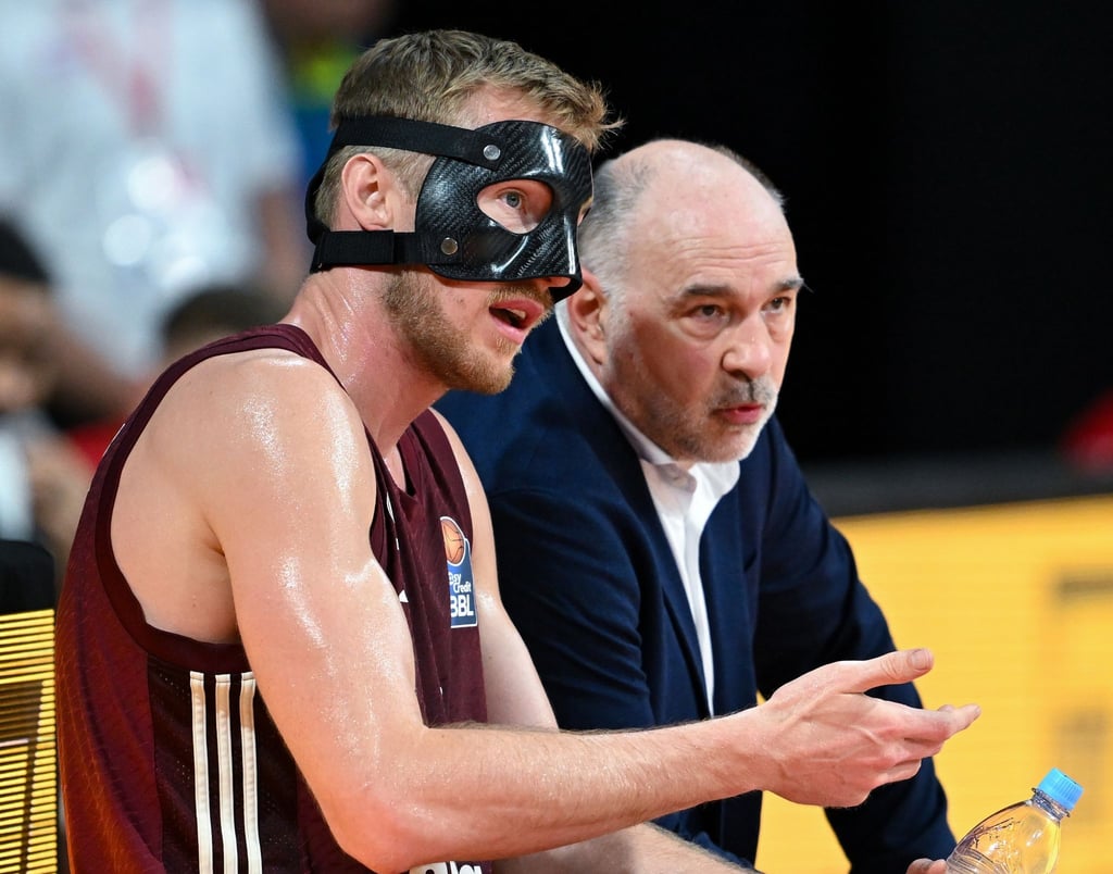 Niels Giffey (l) und Trainer Pablo Laso von München sitzen in einer Pause zusammen.