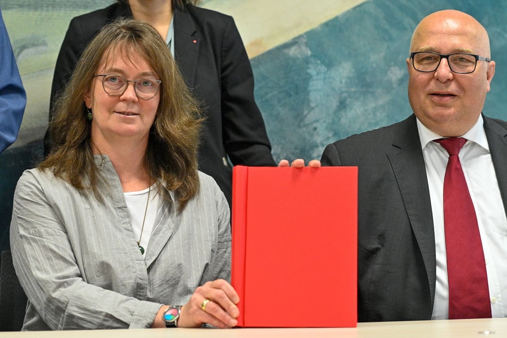 Juliane Kleemann, Vorsitzende der SPD in Sachsen-Anhalt, und Andreas Schmidt, Vorsitzender der SPD in Sachsen-Anhalt, zeigen den Koalitionsvertrag zwischen CDU, SPD und FDP.
